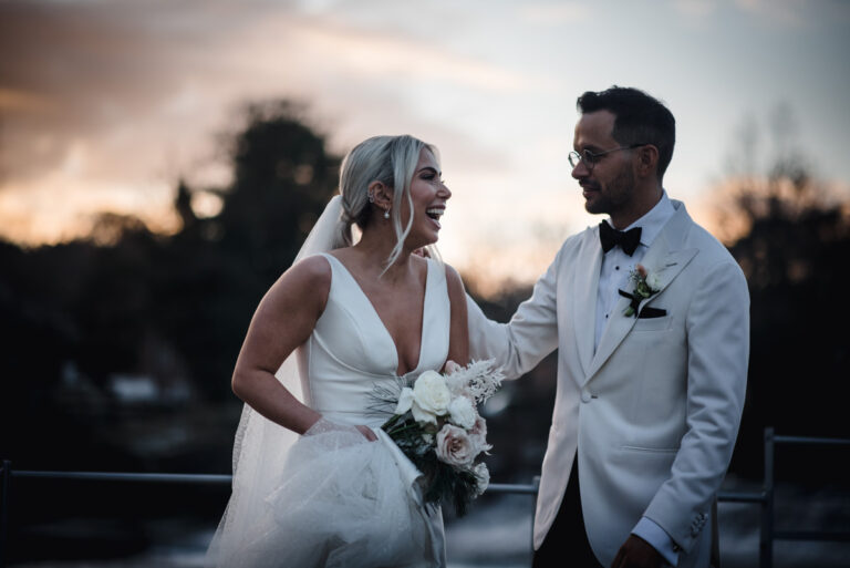 Couple on the banks of the river Derwent at the West Mill Wedding Venue laughing during golden hour portraits